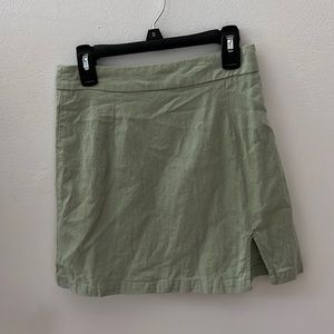 A sage green mini skirt size XS. Fits more like a small and is super cute!